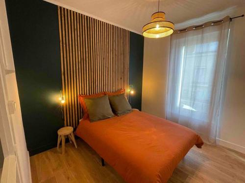 ein Schlafzimmer mit einem orangenen Bett und einem Fenster in der Unterkunft Chez Elo in Tours
