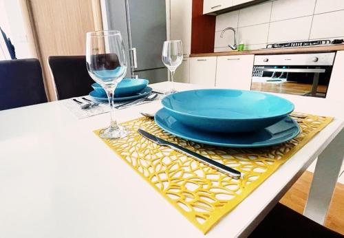 a table with blue plates and glasses on a table at DoMa-Lu apartment with free parking in Velika Mlaka