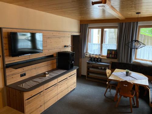 a living room with a television and a table with a dining room at Garni Apart Wallamotta Silvretta Card Premium Betrieb in Galtür
