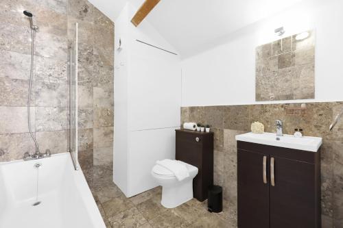 a bathroom with a toilet and a sink and a shower at Large Industrial Style 2 Bedroom Flat! in London