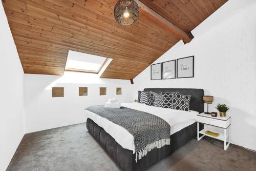 a bedroom with a large bed and a wooden ceiling at Large Industrial Style 2 Bedroom Flat! in London