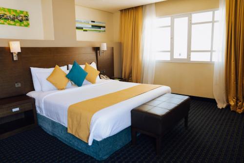 a hotel room with a large bed and a window at Best Western Premier Muscat in Muscat