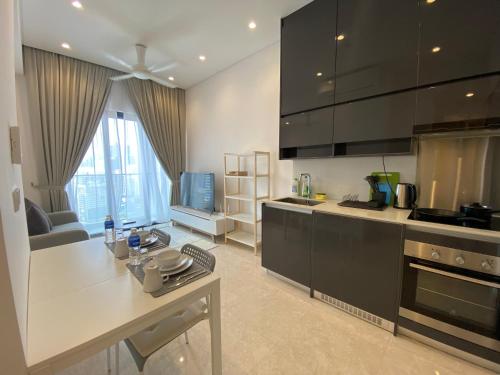 a kitchen with black cabinets and a white counter top at Lalaport Suites At Lucentia Bukit Bintang City Center in Kuala Lumpur