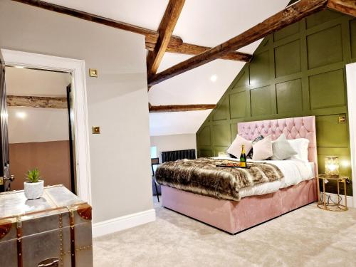 a bedroom with a pink bed and green walls at The Cruck in Preston