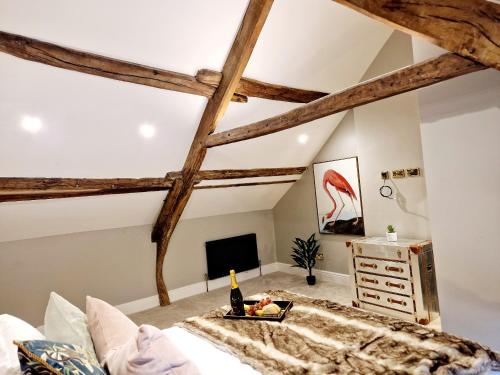 a bedroom with exposed beams and a bed with a bottle of champagne at The Cruck in Preston
