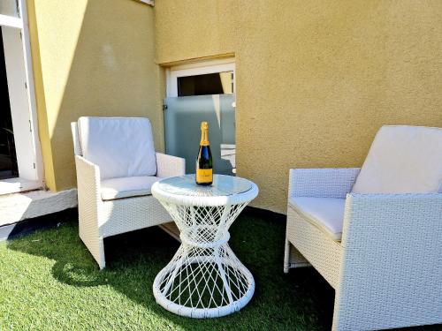 a bottle of wine sitting on a table next to two chairs at The Cruck in Preston