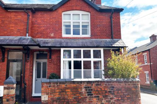 a red brick house with a white window at Shrewsbury Townhouse - Free Parking in Shrewsbury