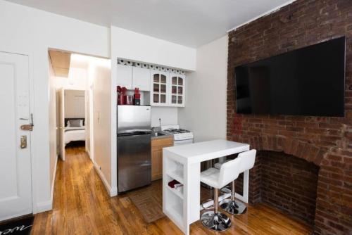 a kitchen with a brick fireplace and a white table at Warm 1-Bedroom Apt in Manhattan in New York