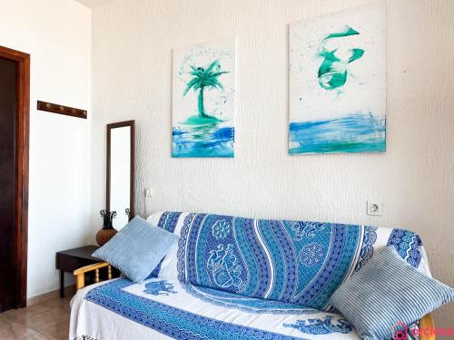 - un salon avec un canapé bleu et des peintures murales dans l'établissement Oasis a 50m del Mar, à Grao de Castellón