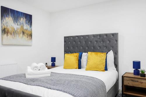a bedroom with a bed with yellow and blue pillows at Cool 2 Bed Basement Flat in Central Shoreditch! in London