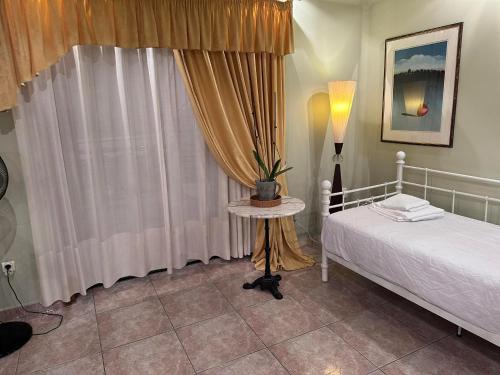 um quarto com uma cama e uma mesa com um candeeiro em Ωραίο διαμέρισμα κοντά στο μετρό em Atenas