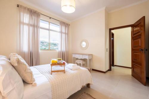 - une chambre avec un lit blanc et une table dans l'établissement Sun View House by GALMI, à Ribeira Brava