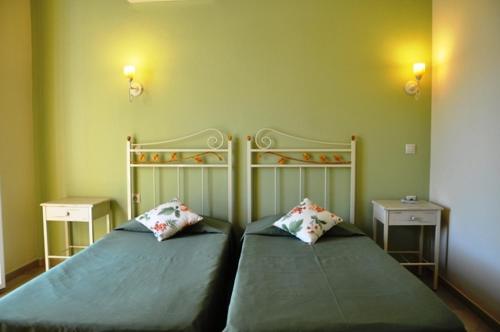 a bedroom with two beds and two night stands at Taxi Driver Apartments in Paleokastritsa