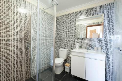 La salle de bains est pourvue de toilettes, d'un lavabo et d'un miroir. dans l'établissement Sun View House by GALMI, à Ribeira Brava