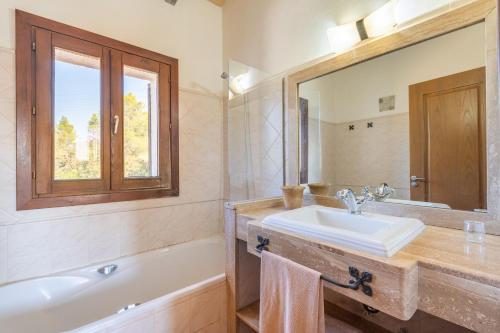a bathroom with a sink and a tub and a mirror at Ca Na Capellana in Sineu