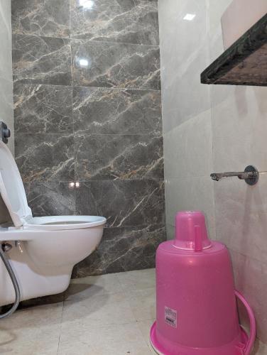 a bathroom with a toilet and a pink container at Ayala PG Dormitory Ac Deluxe1 in Mumbai