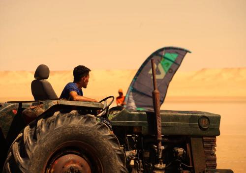 two people sitting on a tractor with a sail on the back at PARAISO DAKHLA in Dakhla