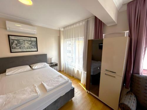a bedroom with a white bed and a large window at Meydan Otel Uskudar in Istanbul