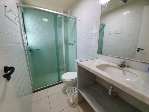 a bathroom with a sink and a toilet and a glass shower at Bangalôs de Peroba in Maragogi