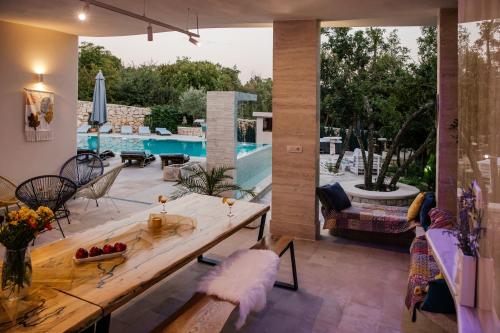 a living room with a table and a pool at VILLA G., Relaxing and Unique nest of Enjoyment in Imotski
