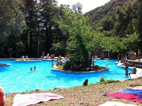 a group of people in a pool with blue water at Montseny Suites & Apartments in Montseny