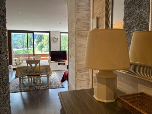 un salon avec une table et une lampe dans l'établissement Grand T4 rénové, 90m², Pra Loup 1600, 8 pers, près des pistes, balcon et box à skis - FR-1-165A-76, à Uvernet