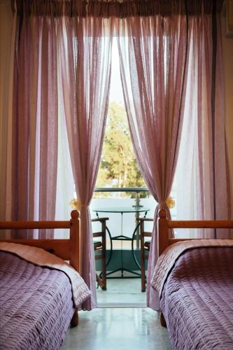a bedroom with two beds and a window with a view at Dimitra Apartments in Kandia
