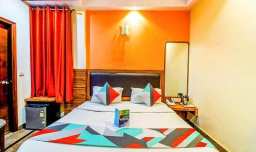 um quarto com uma cama grande e paredes cor-de-laranja em FabExpress JP Palace em Nova Deli
