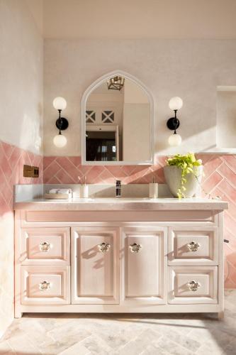 a bathroom with a white sink and a mirror at LohonoStays Villa Athena in Siolim