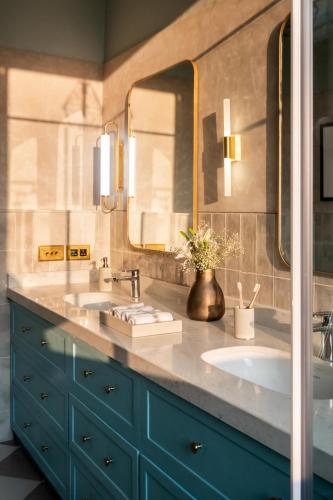 a bathroom with two sinks and two mirrors at LohonoStays Villa Athena in Siolim