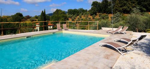 una piscina con 2 sillas y una piscina en AGRITURISMO TERRA VOLONTERI, en Montecatini Terme