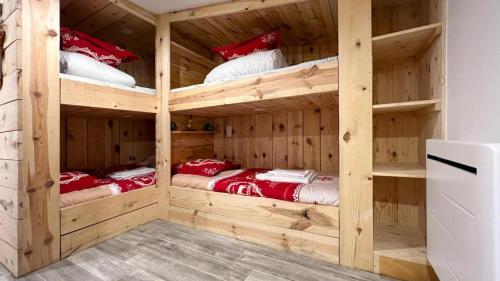Cette chambre en bois comprend 2 lits superposés. dans l'établissement Le Super Refuge de l'Ecureuil, à Enchastrayes