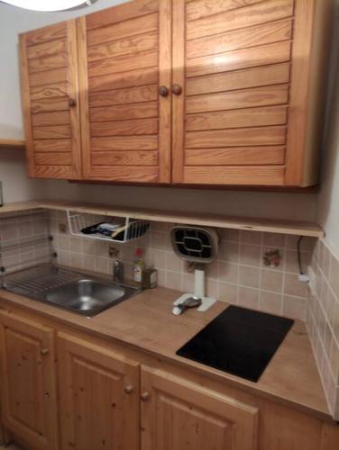 un comptoir de cuisine avec un évier et des armoires en bois dans l'établissement Chambre atypique : La Grotte, à Bez-et-Esparon