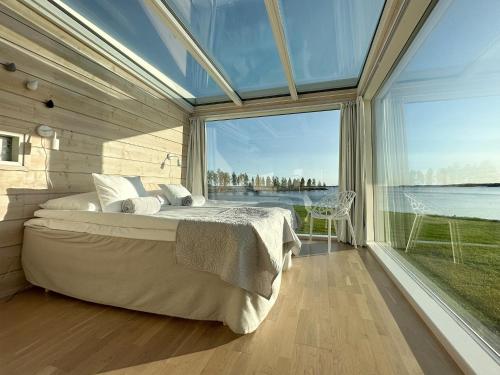 a bedroom with a large bed and a large window at Seaside Glass Villas in Kemi