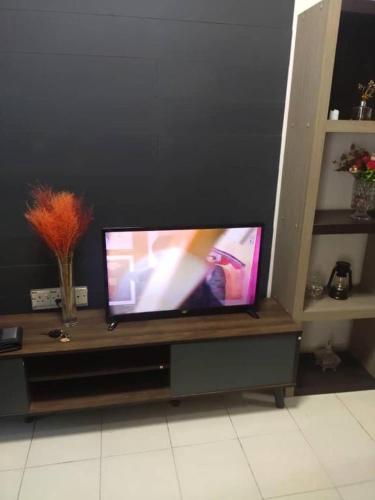 a flat screen tv sitting on a entertainment center at Rumah teres 2 tingkat & 3 bilik in Pasir Gudang
