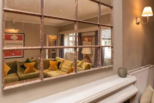 a mirror reflecting a couch in a living room at Spacious Country Cottage Sleeps 7 Near Bath Fire Pit Dog Friendly in Bradford on Avon