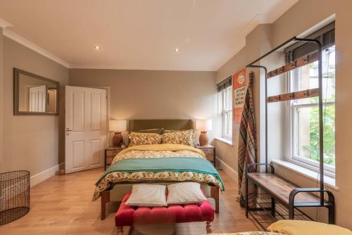 a bedroom with a bed with a red bench in it at Spacious Country Cottage Sleeps 7 Near Bath Fire Pit Dog Friendly in Bradford on Avon