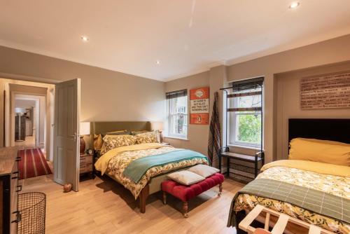 um quarto com 2 camas e uma cadeira em Spacious Country Cottage Sleeps 6 Near Bath +Fire Pit + Dog Friendly em Bradford on Avon