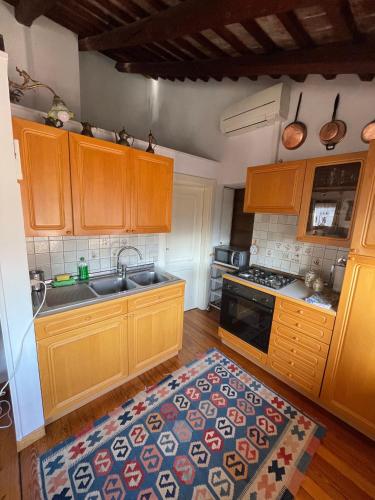 a kitchen with wooden cabinets and a kitchen rug at Regina dei fiori in Marostica
