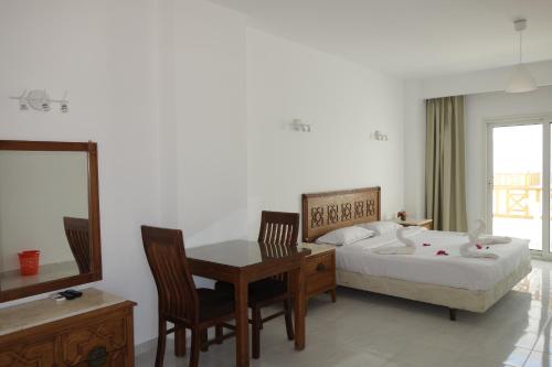 a bedroom with a bed and a table and chairs at Blue Vision Diving Hotel in Marsa Alam City