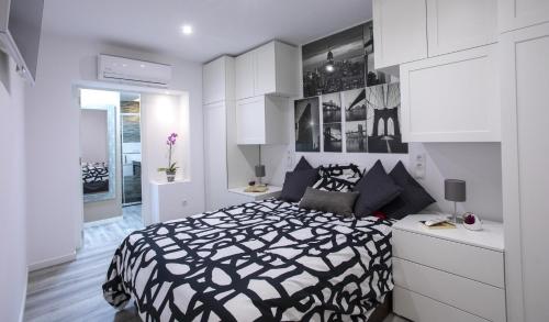 ein Schlafzimmer mit einem schwarz-weißen Bett und weißen Schränken in der Unterkunft Apartamento Virgen del Remedio in Novelda