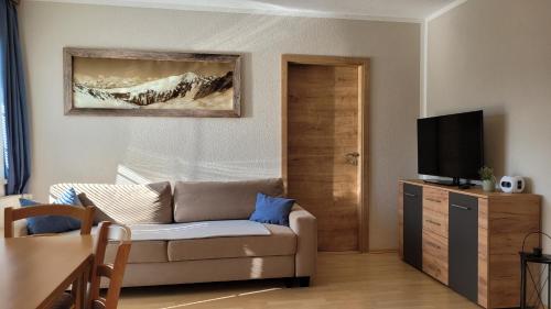 een woonkamer met een bank en een televisie bij Alpenzauber Tilg in Imst