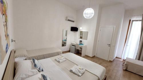 カステッルッツォにあるB&B La mia Isolaのベッドとデスクが備わる小さな白い客室です。