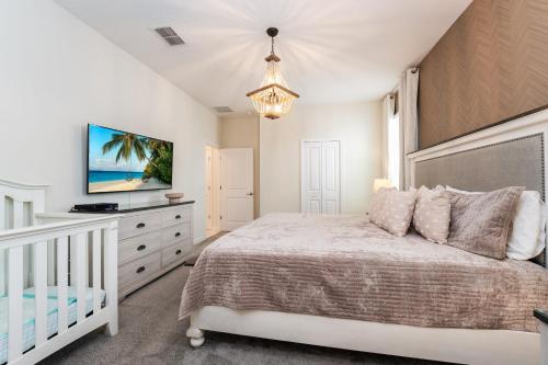 Habitación blanca con cama y cuna en Spacious 8BR Villa by Disney World w Private Pool en Kissimmee