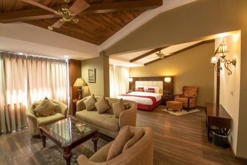 a hotel room with a bed and a living room at Rock Manali by Vivaan in Manāli
