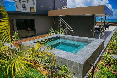 a house with a swimming pool in front of it at Unity Beira Mar de João Pessoa by Carpediem in Penha