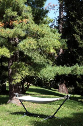 a hammock in the grass next to a tree at Villa Lucini 1886 "La Dolcevita" Cottage 2, close to Lake Como and Milan in Calco