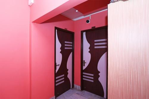 dwa lustra w pokoju z różowymi ścianami w obiekcie OYO Flagship Rainbow Guest House w mieście Jādabpur