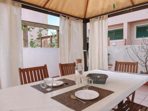 a white table with plates and glasses on it at Supertubos Beach Villa in Atouguia da Baleia