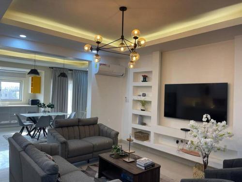 Il comprend un salon doté d'un canapé et d'une télévision à écran plat. dans l'établissement Modern 2 bedroom apartment in Sakumono-Tema Beach Rd, Accra-Ghana, à Accra